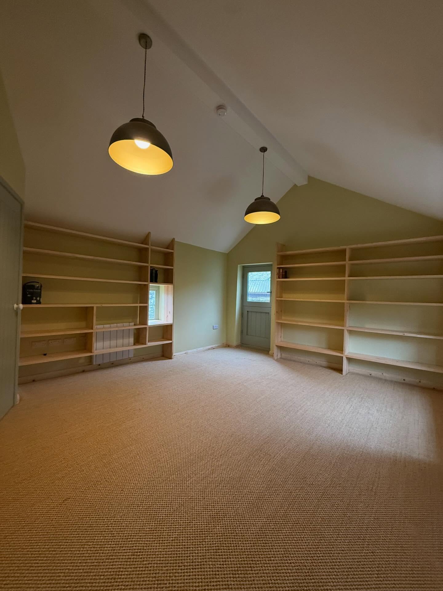 Bespoke fitted shelving built into a vaulted room by SG Construction joiners