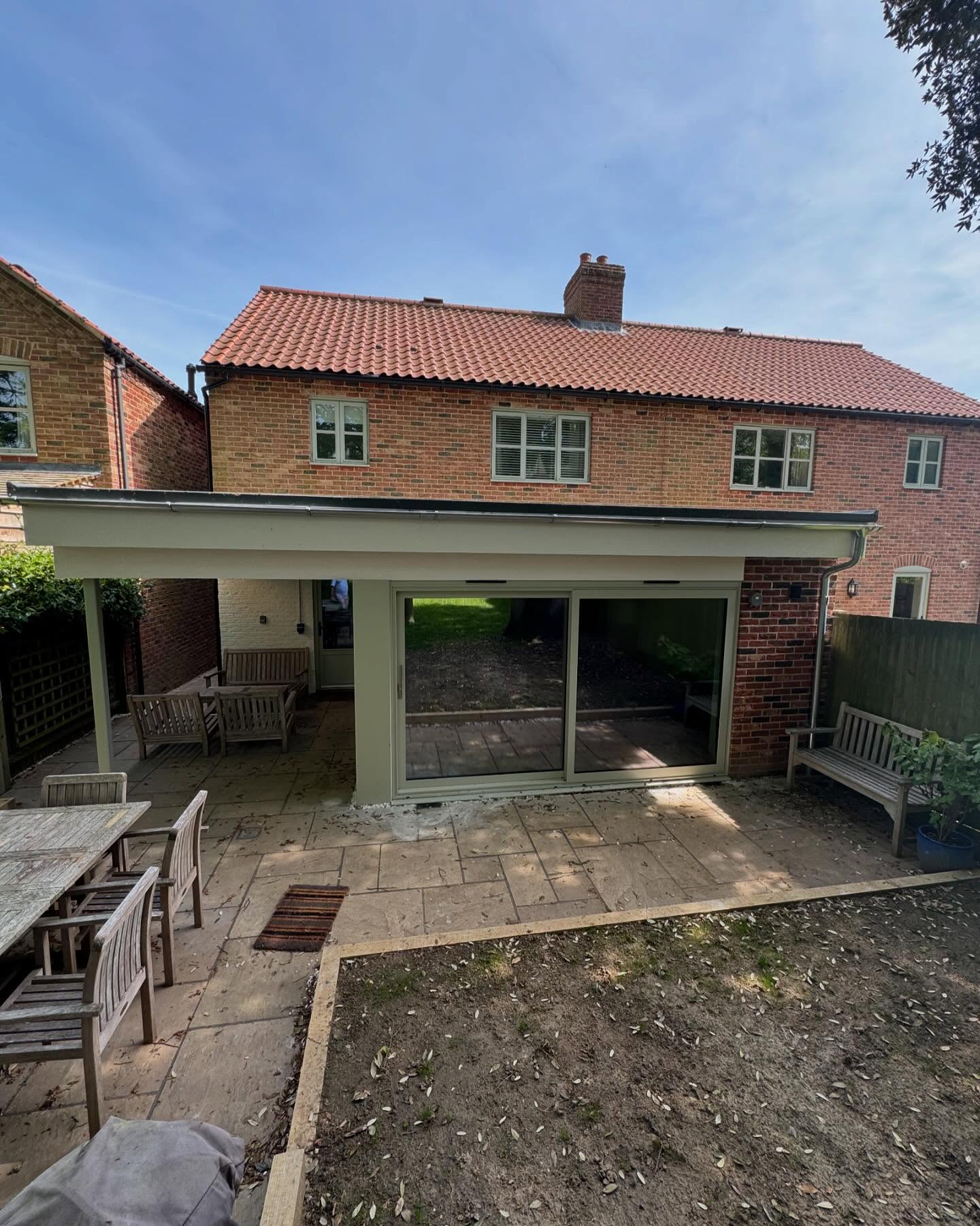 Brick kitchen extensions with a new covered outdoor room and sliding glazed doors